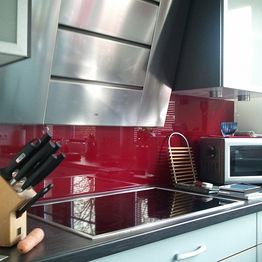 Moderne Küche mit Küchenschild aus rot lackierten Glas