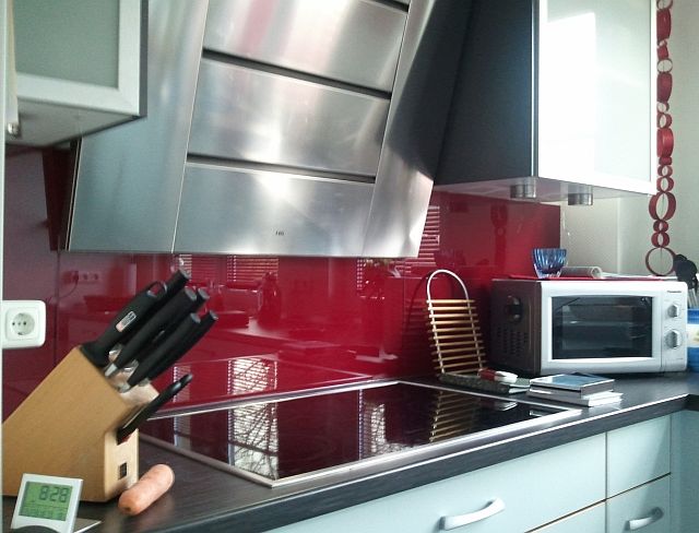 Moderne Küche mit Küchenschild aus rot lackierten Glas